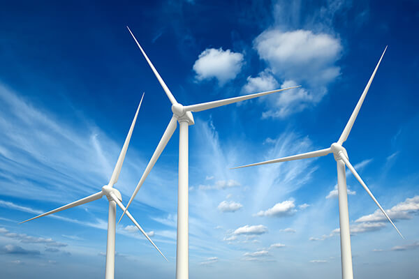 3 wind turbines with blue sky and clouds