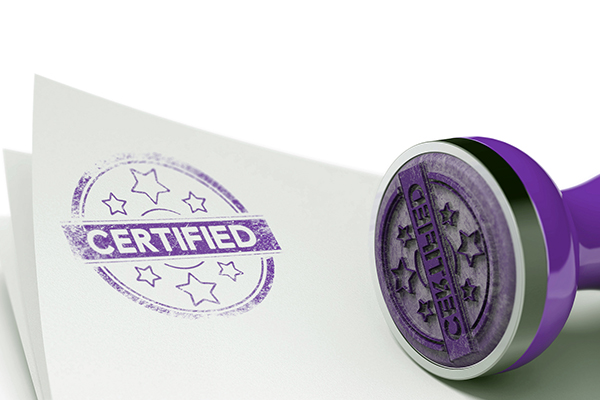A purple certified stamp lies next to a white paper with the stamp applied in purple ink